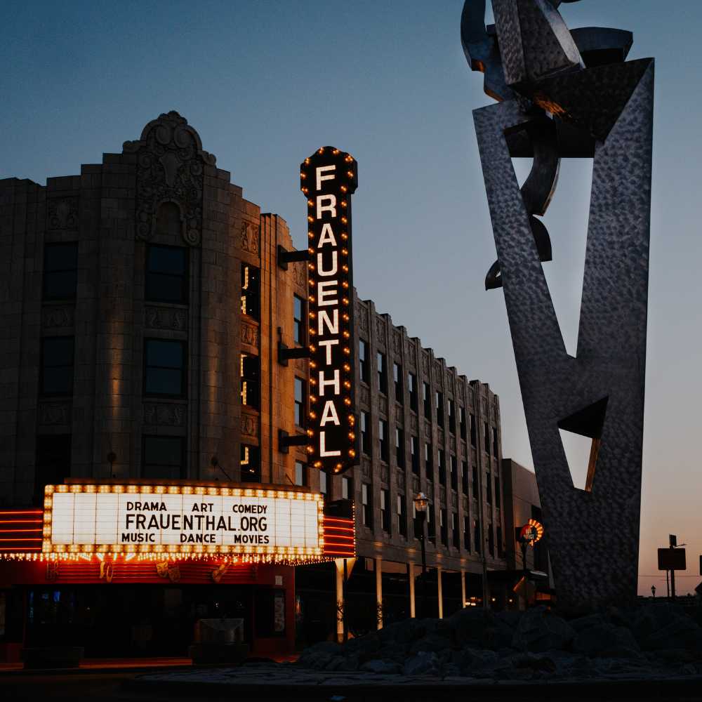 Frauenthal Center exterior at dusk with Muskegon Rising statue